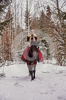 A girl in a beautiful old-fashioned burgundy dress on a horse .