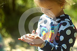 Girl in the beautiful park, with a net catches butterflies, smiles and laughs, playful mood, childish pranks