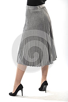 girl with beautiful slender legs in a long ruffled skirt on a white background, long gray ruffled skirt