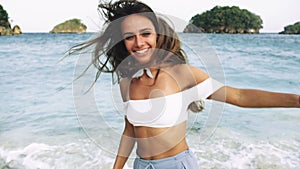 girl with beautiful smile and long hair laughing on the beach and running
