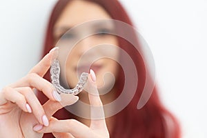 Girl with a beautiful smile shows a transparent mouth guard photo