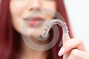 Girl with a beautiful smile shows a transparent mouth guard photo