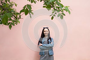 Girl with a beautiful smile stands near a pink clean wall