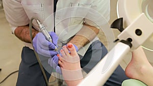 Girl in a beauty salon doing a pedicure. Feet care procedure, medical pedicure. The process of professional pedicure.Spa treatment