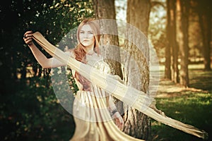 Girl beauty in wood with tissue on wind