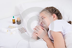 girl in bed, doing inhalation, putting on a mask in bed and looking at medication-tablets