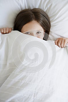 Girl In Bed Pulling Blanket Over Face