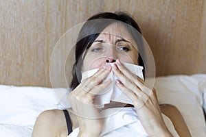 Girl in bed, Sinus pain, sinus pressure, sinusitis. Sad woman holding her nose and head because sinus pain. Sinus ache causing
