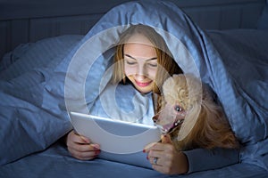 Girl on the bed with tablet.