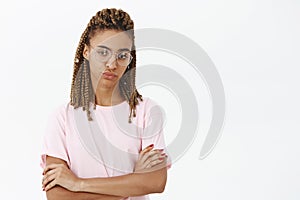 Girl beeing uninterested and unimpressed. Portrait of displeased indifferent attractive dark-skinned female smirking photo