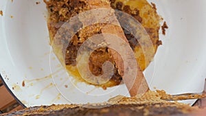 Girl beekeeper Unseal Honeycomb. A close-up knife opens honeycomb with honey on frame made of beehive.