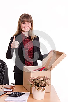 The girl behind the office desk with a box showing thumb