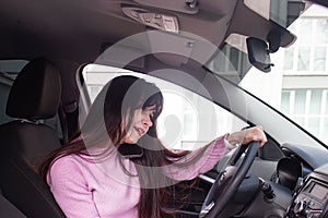 Girl behind the wheel of the car is talking on the phone