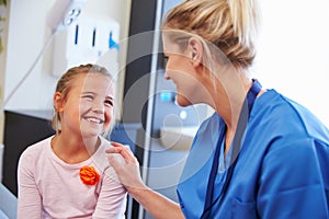 Girl Being Reassured By Nurse In Hospital Room photo