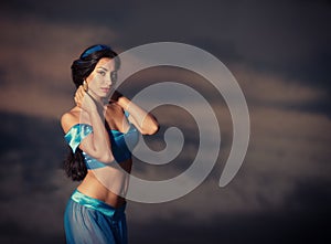 Girl in belly dance costume at sunset