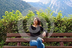 Girl on the bench on the background of Alps