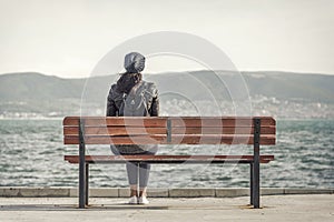 Girl on the bench near the sea.