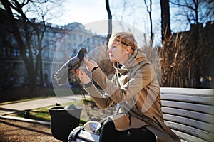 Girl on the bench stroking a dove