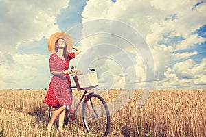 Girl with bicycle on field.