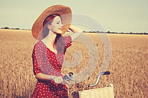 Girl with bicycle on field.