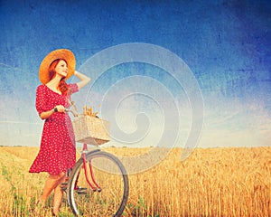 Girl with bicycle on field.