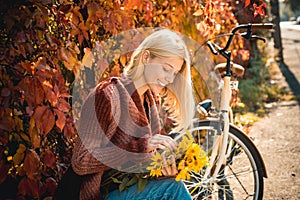 Girl with bicycle and flowers. Woman bicycle autumn garden. Active leisure and lifestyle. Autumn simple pleasures. Girl