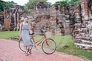 Girl with bicycle in front ancient Ayutthaya ruins , Thailand