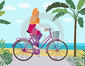 girl on bicycle in hijab near beach riding