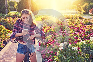 Girl bicycle playing with smartphone in park