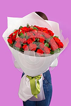 The girl with big bouquet of red flower roses