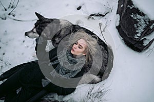 Girl with big malamute dog on winter background.