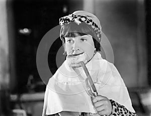 Girl with a big napkin eating a piece of bread