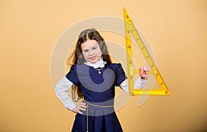 Girl with big ruler. School student study geometry. Kid school uniform hold ruler. School education concept. Learn