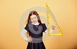 Girl with big ruler. School student study geometry. Kid school uniform hold ruler. School education concept. Learn