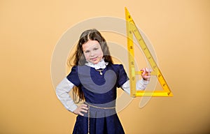 Girl with big ruler. School student study geometry. Kid school uniform hold ruler. School education concept. Learn photo