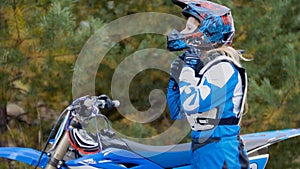 Girl Bike wears a helmet - MX moto cross racing - rider on a dirt motorcycle