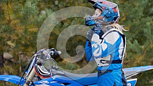 Girl Bike wears a helmet - MX moto cross racing - rider on a dirt motorcycle photo