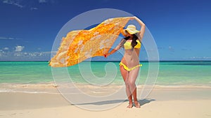 Girl with bikini and hat enjoying her summer Caribbean vacation. Exotic island and beach.