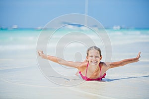 Girl in bikini lying and having fun on tropical beach photo