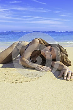Girl in bikini lying on a sandy beach