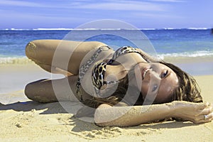 Girl in bikini lying on a sandy beach