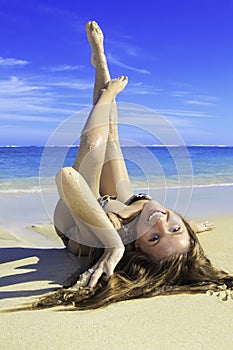 Girl in bikini lying on a sandy beach