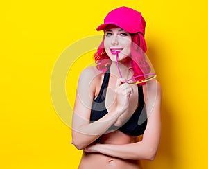 Girl in bikini and orange glasses with cap