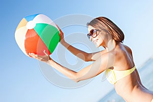 Girl in bikini playing ball on the beach