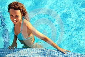 Girl in bikini stands in swimming-pool
