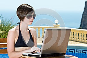 Girl in Bikini Using her Laptop Poolside