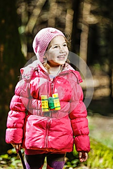 Girl with binoculars in the forest