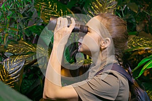 Girl with binoculars in the jungle