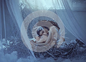The girl bird sits in her nest, timidly bowing her head and embracing her legs. A nest in a fairy-tale house, near the