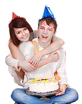 Girl in birthday hat kiss man with cake.